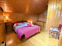 a bedroom with a bed in a wooden cabin at Gîte Anould, 4 pièces, 6 personnes - FR-1-589-2 in Anould