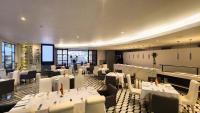 Un comedor con mesas y sillas blancas. en Hotel Dann Carlton Medellín, en Medellín