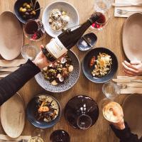 Towan House at Carrick Winery في كرومويل: طاولة مع زجاجة من النبيذ وأطباق من الطعام