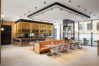 um restaurante com mesas e cadeiras em uma sala em Courtyard by Marriott Cluj - Napoca Downtown em Cluj-Napoca