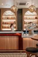 a restaurant with a bar with two people standing behind it at Oaks Townsville Hotel in Townsville