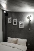 a bedroom with a white bed and pictures on the wall at HL53 B&amp;B in Hualien City