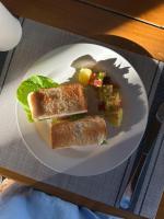 a white plate with two sandwiches and vegetables on a table at La Pang Resort 라팡리조트 in Panglao