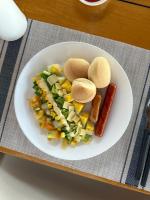 a plate of food with sausage and vegetables on a table at La Pang Resort 라팡리조트 in Panglao