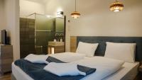 A bed or beds in a room at Napsugár Club és Panzió