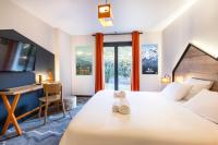a bedroom with a bed with a desk and a window at Hotel Base Camp Lodge - Albertville in Albertville