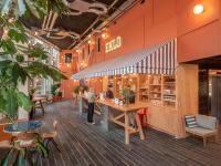 a restaurant with orange walls and people standing at a counter at Eklo Paris Expo Porte de Versailles in Vanves