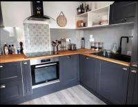 une cuisine avec des placards bleus et un comptoir dans l&#39;établissement Duplex Cosy 100m2 Terrasse Fouesnant Les Glénan, à Fouesnant