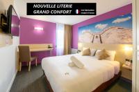 Una habitación de hotel con una cama grande y un escritorio. en BRIT HOTEL Confort CAMBRAI, en Cambrai