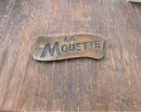 a sign on a wooden floor with the word la monster at Gîte La Mouette de 4 personnes in Pontorson