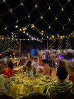 een groep mensen die 's avonds aan een eettafel zitten bij Imperial Glory Lodges in Merzouga