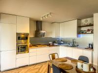 a kitchen with white cabinets and a table with chairs at L’Escale Borely in Marseille