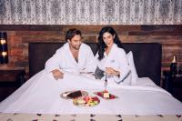 Ein Mann und eine Frau sitzen im Bett mit einem Teller Essen in der Unterkunft Silverton Casino Lodge in Las Vegas