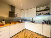 a kitchen with white cabinets and a wooden floor at L’Escale Borely in Marseille