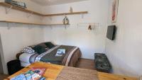 a room with two beds and a table and a tv at STUDIO avec PARKING TOUT A PIED et CALME in Bandol