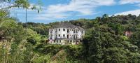 una gran casa blanca en medio del bosque en Rovers Inn Guesthouse - Age 11 And Above Only, en Tanah Rata