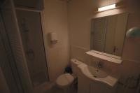 a bathroom with a sink and a toilet and a mirror at Hotel Wilson Square in Toulouse