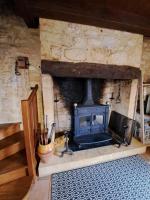 a stone fireplace with a stove in a room at Maison Domme Dordogne in Domme