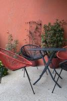 a table and two chairs in front of a red wall at E Fauvette appartement de standing avec terrasse in Épernay