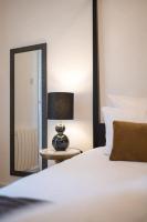 a bedroom with a bed with a lamp and a mirror at E Fauvette appartement de standing avec terrasse in Épernay
