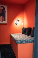 a bedroom with a bed with an orange wall at E Fauvette appartement de standing avec terrasse in Épernay