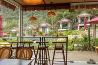 Un bar con taburetes y vistas a un resort. en YEN Hidden Valley, en Cat Ba