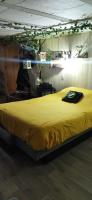 a large bed in a room with a yellow blanket at La chambre secrète in Longueval
