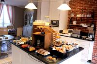 a kitchen with a counter with various types of pastries at Domaine du Clos Fleuri - Spa in Honfleur