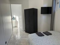 a bedroom with a bed and a black cabinet at La maison de Giulia Menton in Menton