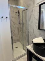 a shower with a glass door in a bathroom at La maison de Giulia Menton in Menton