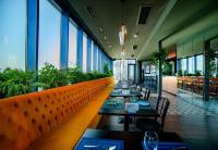 a restaurant with tables and chairs and large windows at King David Residence Tbilisi - 2 Bedroom Luxury Apartment in Tbilisi City