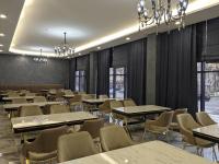 ein Esszimmer mit Tischen und Stühlen und Kronleuchtern in der Unterkunft MirOtel in Schymkent