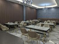 ein Esszimmer mit Tischen und Stühlen und Kronleuchtern in der Unterkunft MirOtel in Schymkent