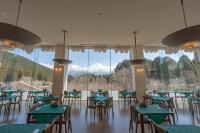 un restaurante con mesas y sillas y vistas a la montaña en Kyukamura Fuji, en Fujinomiya