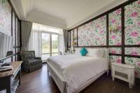 a bedroom with a bed with pink floral wallpaper at Kenting 4 Sisters Villa in Eluan