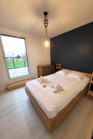 a large bed in a bedroom with a large window at TY COAT - Maison neuve avec vue mer, piscine et bain nordique in Saint-Pabu