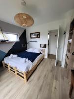 a bedroom with a large bed in a room at TY COAT - Maison neuve avec vue mer, piscine et bain nordique in Saint-Pabu