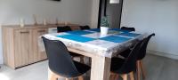 una mesa de comedor con sillas negras y una mesa con una planta. en Appartement Entre terre et mer, en Dunkerque