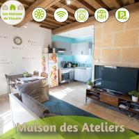 a living room with a large television and a kitchen at Ateliers, Terrasse - Parking - Clim in Arles