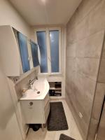 a white bathroom with a sink and a window at Cosy Appartement in Paris 15th - Convention Center in Paris