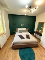 a bedroom with a large bed with a green wall at Ay central in Ay