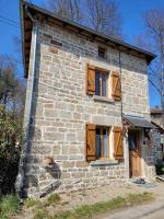 an old stone house with wooden windows on the side at Maison dans un havre de paix in Saint-Julien-le-Petit