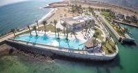 - une vue aérienne sur une piscine à côté d'une plage dans l'établissement Le Sifah - Marina View Apartments & Villa, à As Sīfah