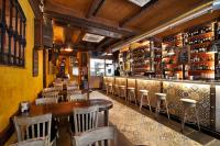 Un restaurante con mesas y sillas y un bar. en Apartamentos El Tiempo, en Madrid