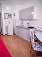 a kitchen with white cabinets and a table and chairs at Flowers Apartment Tuzla in Tuzla