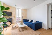 a living room with a blue couch and a table at Charmant appartement haut de gamme in Bordeaux