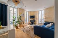 a living room with a blue couch and some windows at Charmant appartement haut de gamme in Bordeaux