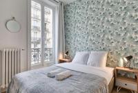 a bedroom with a large bed with a floral wall at Appartement luxueux proche Arc-de-Triomphe - 4P in Paris