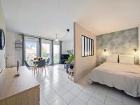 a bedroom with a bed and a kitchen with a table at Prague - 10min de Disneyland Paris Parking privé in Montévrain