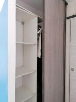 a closet with white shelves and a door at F2 Blanc Bleu in Sainte-Marie-la-Mer